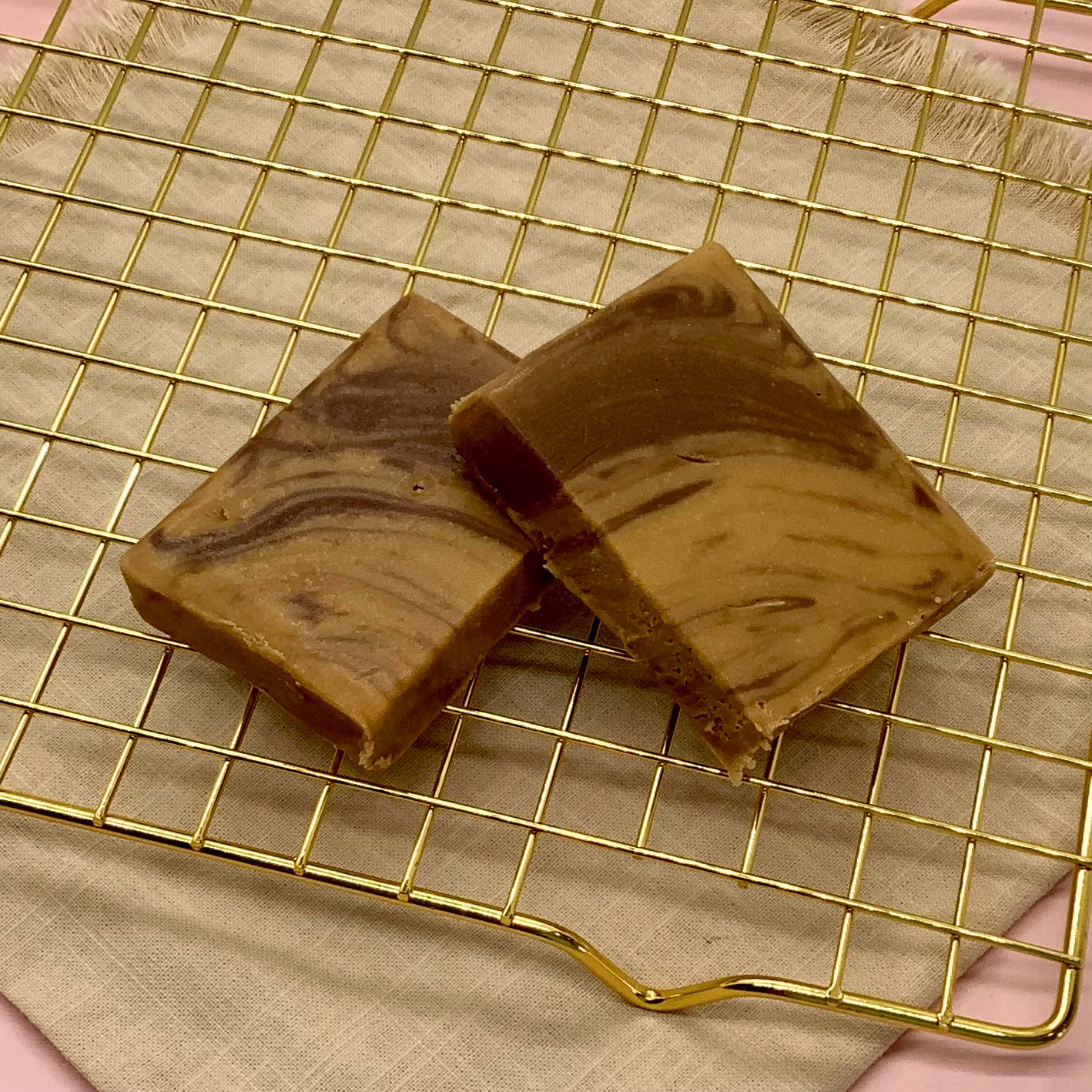 Swirled chocolate caramel fudge squares on a gold cooling rack