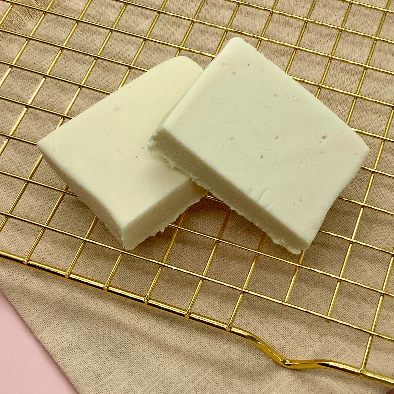 White horchata fudge blocks cut into rectangles on a gold cooling rack.