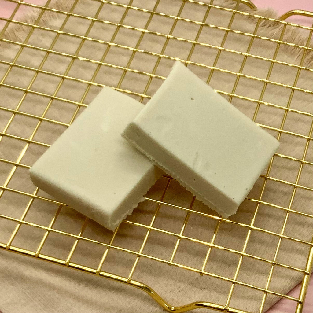 Two white maple fudge blocks on a gold cooling rack