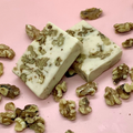 Maple Walnut Fudge with walnut chunks on a pink background