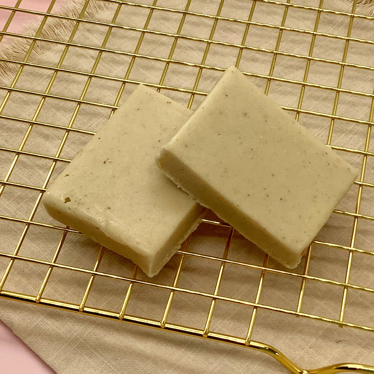 Creamy peanut butter fudge squares on a gold cooling rack