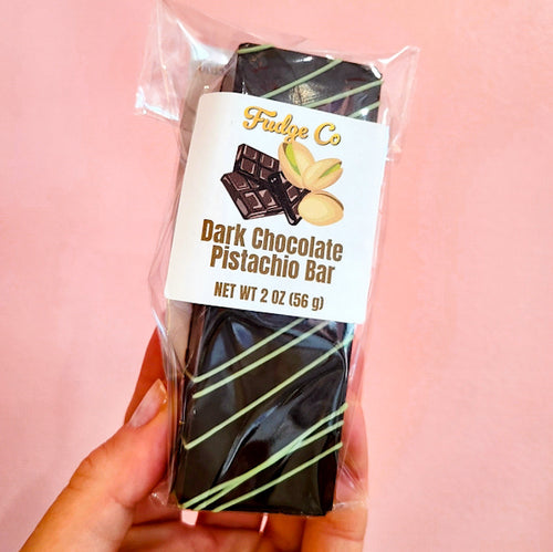 Dark Chocolate Pistachio Bar with pale green drizzle, wrapped in clear plastic with a white Fudge Co label