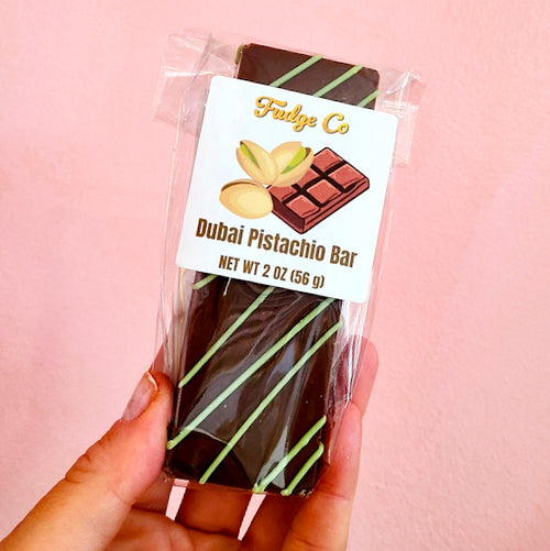 Dubai Pistachio Bar dark chocolate with green drizzle, wrapped in clear plastic with a white Fudge Co label