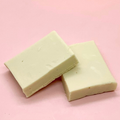Creamy vanilla fudge blocks on a pale pink background
